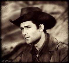 a black and white photo of a man wearing a cowboy hat