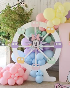 there is a large clock with balloons on the floor next to it and some other decorations