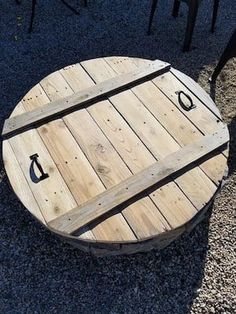 a wooden table sitting on top of gravel covered ground