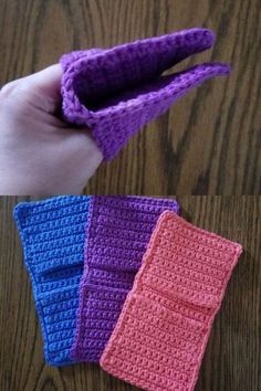 three crocheted wallets sitting on top of a wooden table next to a person's hand