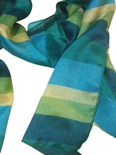 An effortless way to add a pop of color to any outfit! This versatile scarf is just the right weight to keep you comfortable while making a bold, fashion-forward statement. Crafted with a lightweight, high-quality blend of green, teal, and yellow, it's sure to turn heads. Designed with convenience in mind, this scarf is lightweight and easy to fold, making it ideal for travel or a night out. Plus, it's soft on the skin and won't irritate even the most sensitive skin. So no matter the season or o Trendy Green Silk Scarf For Spring, Striped Scarf, Form Fitting Dress, Striped Scarves, Lightweight Scarf, Yellow Stripes, Pet Hair, Sensitive Skin, Fashion Forward