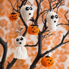 crocheted halloween decorations hanging from a tree with pumpkins and ghost faces on them