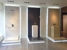 three white pedestals are in the middle of a room with marble walls and flooring