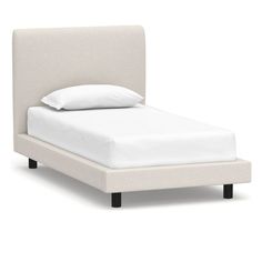 a bed with white sheets and pillows on it