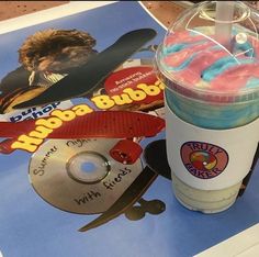 there is a cup with doughnuts and cd on the table