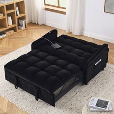 a black couch sitting on top of a white rug