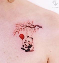 a panda bear tattoo on the back of a woman's upper shoulder and chest