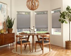 a dining room table and chairs with blinds on the windows