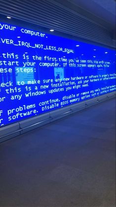 a blue wall with words written on it in front of a computer screen at an airport