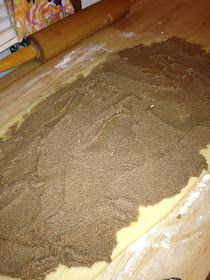 a wooden table topped with lots of brown stuff next to a rolling pin on top of a hard wood floor