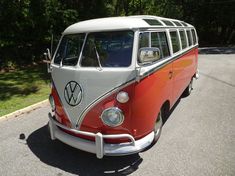 an orange and white vw bus parked on the street