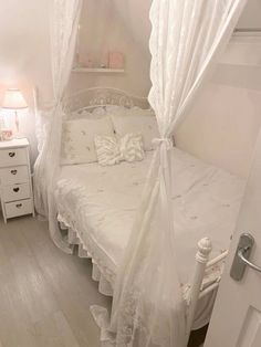 a white bed sitting inside of a bedroom next to a doorway