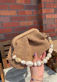 a woman's hand is holding up a purse with pearls on the inside and outside