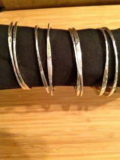 Thick and thin sterling silver bangles.  These bangles are hand hammered out of 10 guage sterling silver.  They are organically irregular for that unique look.    3 for $125.00.  71/2- 73/4 in circumference. Hammered Metal Jewelry, Hammered Silver Jewelry, Womens Silver Jewelry, Stackable Bangles, Silver Jewelry Earrings, Silver Jewelry Design, Hammered Sterling Silver, Silver Jewelry Rings, Sterling Silver Bangles