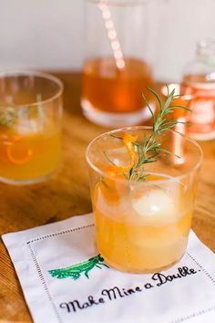 two glasses filled with drinks sitting on top of a wooden table