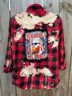 This is a one of a kind Oliver Anthony plaid flannel shirt.  This size SMALL plaid shirt has two pockets on the front, buttons up and is long sleeve. On the back of the shirt is a Oliver Anthony tee that has been sewn into the back of the shirt. The flannel has been bleach and is frayed around the tee giving it an overall distressed vintage style look.  All my shirts are ONE OF A KIND. They are all upcycled by being previously owned so there will be signs of wear and tear. This is what make each shirt unique in its own way and for sure makes them the most comfortable.  *NOTE: ALL of our shirts are MENS sizes unless otherwise stated above.  Upcycled/Bleached/Distressed Long Sleeve Size Small 100% Cotton Button Up Here are some ways to style your flannels.  1) wear cowboy boots or tennis Plaid Flannel Shirt With Pockets, Americana Style Cotton Tops For Fall, Casual Flannel Shirt With Graphic Print, Distressed Long Sleeve Shirt For Fall, Plaid Flannel Shirt With Graphic Print For Streetwear, Distressed Button-up Shirt For Fall, Fall Flannel Shirt With Graphic Print, Flannel Shirt With Pockets For Streetwear, Fall Long Sleeve Flannel Shirt With Graphic Print