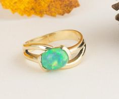 This green oval opal ring has a lovely split band. The opal is securely set with four prongs. This ring is a great gift for your opal lovers or your October babies. The rich 14k yellow gold brings out the warm tones in the stone.  Normal Price: $795.00 Metal: 14k Yellow Gold Gemstone Type: Opal Gemstone Shape: Oval  Gemstone Dimensions: 9 x 7mm  1.10 carat weight Design Elements: prong setting, solitaire ring, yellow gold Condition: New ring, estate opal  (excellent condition) Item Weight: 4.7g Elegant Green Opal Ring Oval Cabochon, Elegant Green Opal Ring With Oval Cabochon, Elegant Green Opal Oval Ring, Green Oval Opal Ring With Polished Finish, Polished Opal Ring In Oval Cabochon Shape, Opal Oval Cabochon Ring With Polished Finish, Polished Opal Oval Cabochon Ring, Fine Jewelry Oval Opal Ring With Polished Finish, Green Oval Opal Ring