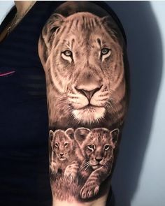 a woman's arm with a lion and cubs tattoo on it