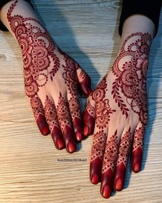 two hands with henna tattoos on them, one is red and the other is white