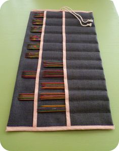 a piece of fabric with different colored pins on it sitting on top of a table