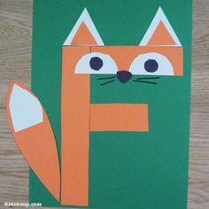 a paper cut out of a fox with eyes and nose sitting on top of a wooden table