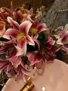 a bouquet of pink flowers sitting on top of a sink