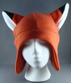 a white mannequin head wearing an orange hat with horns on it's ears