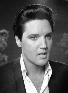 a black and white photo of a man in a suit looking off to the side