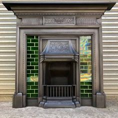 an ornate fireplace in front of a green tiled wall