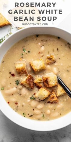 a white bowl filled with soup and croutons