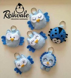 six blue and white birds are hanging from key chains