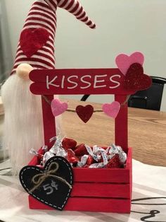 a red wooden box filled with candy and a white gnome sitting on top of it