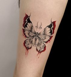 a woman's thigh with a butterfly tattoo on her left leg and red ink running down the side