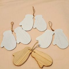 six wooden angel ornament hanging from twine string on beige cloth covered surface