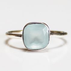 This gorgeous hand-crafted semi-precious stone solitaire ring features a faceted natural gemstone set in solid 925 sterling silver.  Band Material: 100% solid 925 sterling silver  Stone: Faceted Aquamarine Natural Stone Stone Colour: Blue Stone Size: 10mm square Band Sizes: US Size 6, 7, 8 , 9 or 10 Materials: Each one-of-a-kind piece of jewellery is lovingly hand crafted using top quality semi-precious natural gemstones and solid 925 sterling silver, so that you can treasure your piece for a li Silver Sapphire Ring With Rectangular Gemstone, Classic Stackable Topaz Ring As Gift, Square Cut Topaz Ring Gift, Square Cut Sterling Silver Gemstone Rings, Square Cut Crystal Gemstone Ring Gift, Classic Stackable Topaz Ring Gift, Rectangular Sapphire Birthstone Ring As Gift, Silver Faceted Sapphire Ring As Gift, Faceted Silver Sapphire Ring As Gift