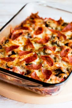 pepperoni and cheese casserole in a glass baking dish on a wooden table