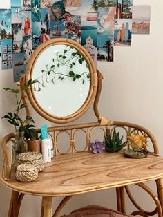 a mirror sitting on top of a wooden table next to a wall covered in pictures