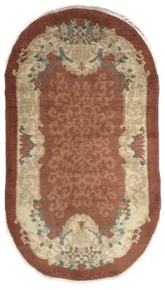 a rug with an oval design on the center and border in red, beige and green colors