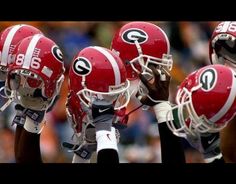 three football players in red and white uniforms with their hands on each other's heads