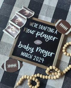 a baby's birth announcement with beads and footballs on the table next to it