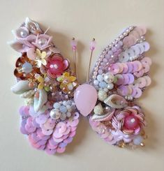 there is a butterfly made out of buttons and other things on the wall with it's wings