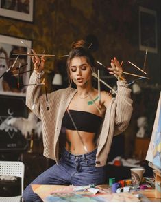 a woman is sitting at a table with clothes pins in her hands