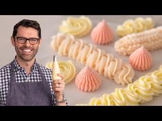 a man holding a pastry knife in front of some icing and other desserts