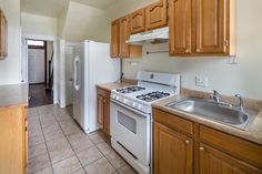 a kitchen with white appliances and wooden cabinets