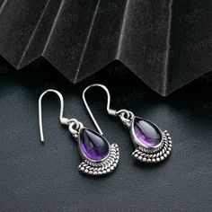 Enhance your jewellery collection with these exquisite sterling silver pear cut purple amethyst gemstone earrings. The earrings are elegantly designed to add a touch of sophistication to your overall look. Length 27mm Gemstone size: 9mm x 6mm * Gemstone: The earrings feature a stunning pear cut purple amethyst gemstone that exudes beauty and charm. * Premium Quality: Crafted with 925 Sterling Silver, the earrings are durable and have an exquisite finish that will last for years. * Elegant Design: The fan-shaped design of the earrings is unique and eye-catching, making them perfect for adding a touch of glamour to any outfit. The drop size of these dangle earrings is 27mm, making them perfect for both formal and casual occasions. Pair them with your favorite outfit or give them as a gift to Amethyst Set, Amethyst Stones, Fan Design, Fan Earrings, Drop Dangle Earrings, February Birth Stone, Fine Jewellery Earrings, Amethyst Stone, Amethyst Gemstone