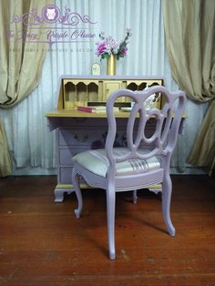 a purple chair sitting in front of a desk with a mirror on top of it