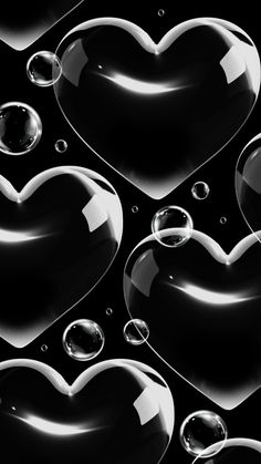 some bubbles in the shape of hearts on a black background