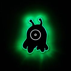 a neon green glowing object with an eyeball on it's backlit side