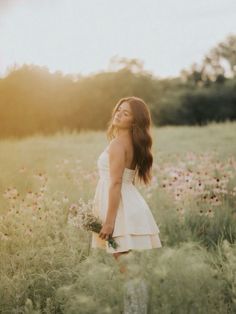 a woman standing in a field with flowers