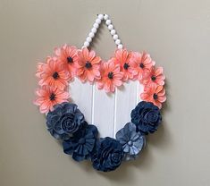 a heart shaped wall hanging with flowers on it